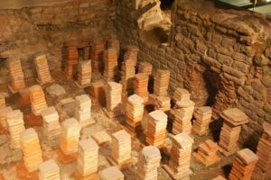 Essas pilhas de azulejos mostram o que resta da engenhosidade romana do aquecimento por piso. (Creative Commons, crédito- Mike Peel).